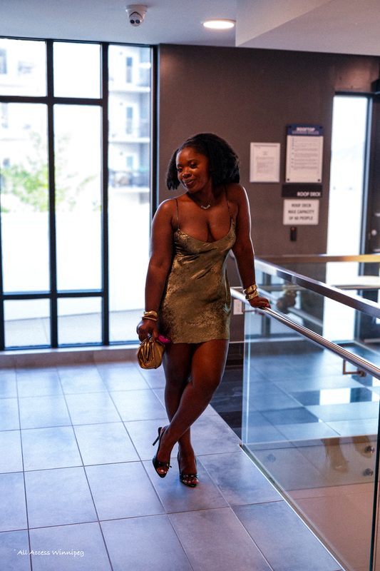 Guest in a gold dress leaning on the rooftop railing, P0PS x FOLA night, Winnipeg