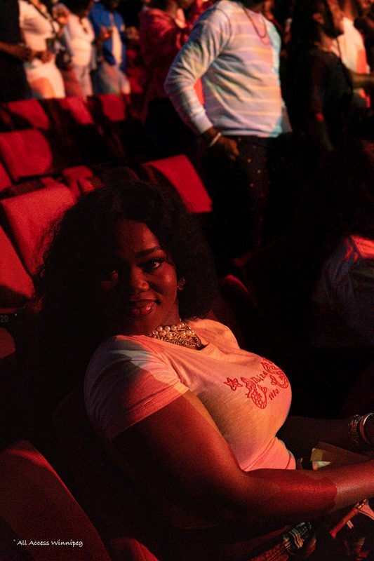 Fan in the crowd lit by stage light, P0PS x Young Jonn, Winnipeg