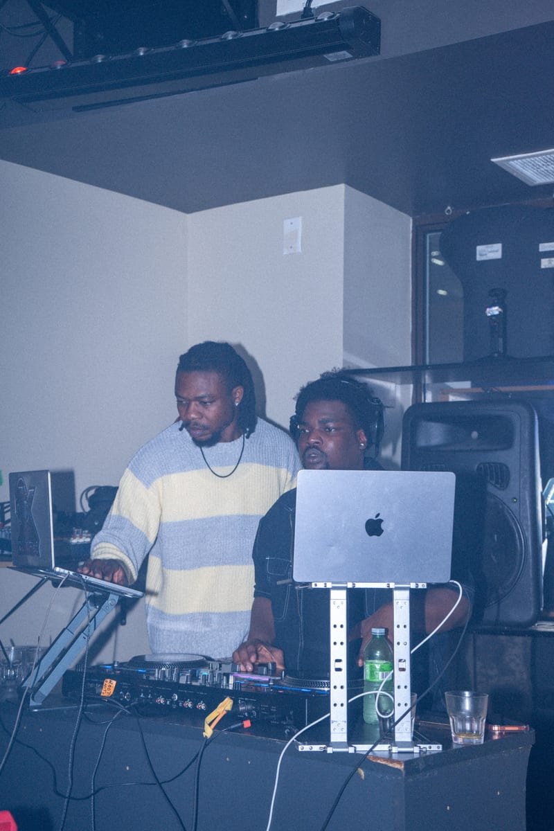 Wide shot of the DJ booth with two DJs at the decks
