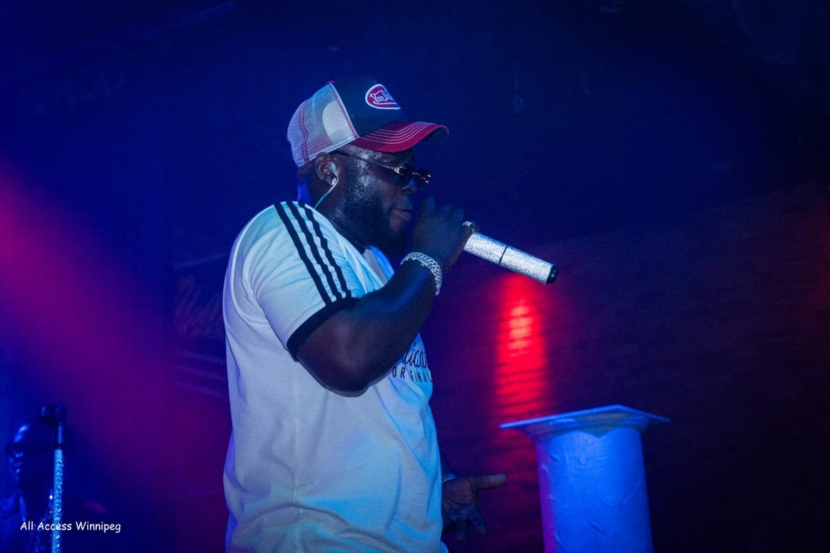 Performer singing into the mic on stage, blue and red light