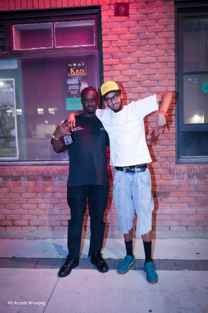 Two guests posed together, one with arms raised