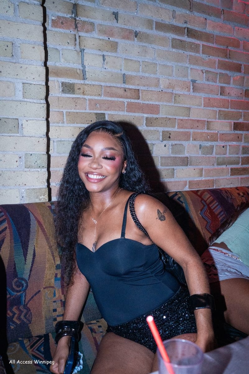 Guest smiling in the lounge, brick wall behind