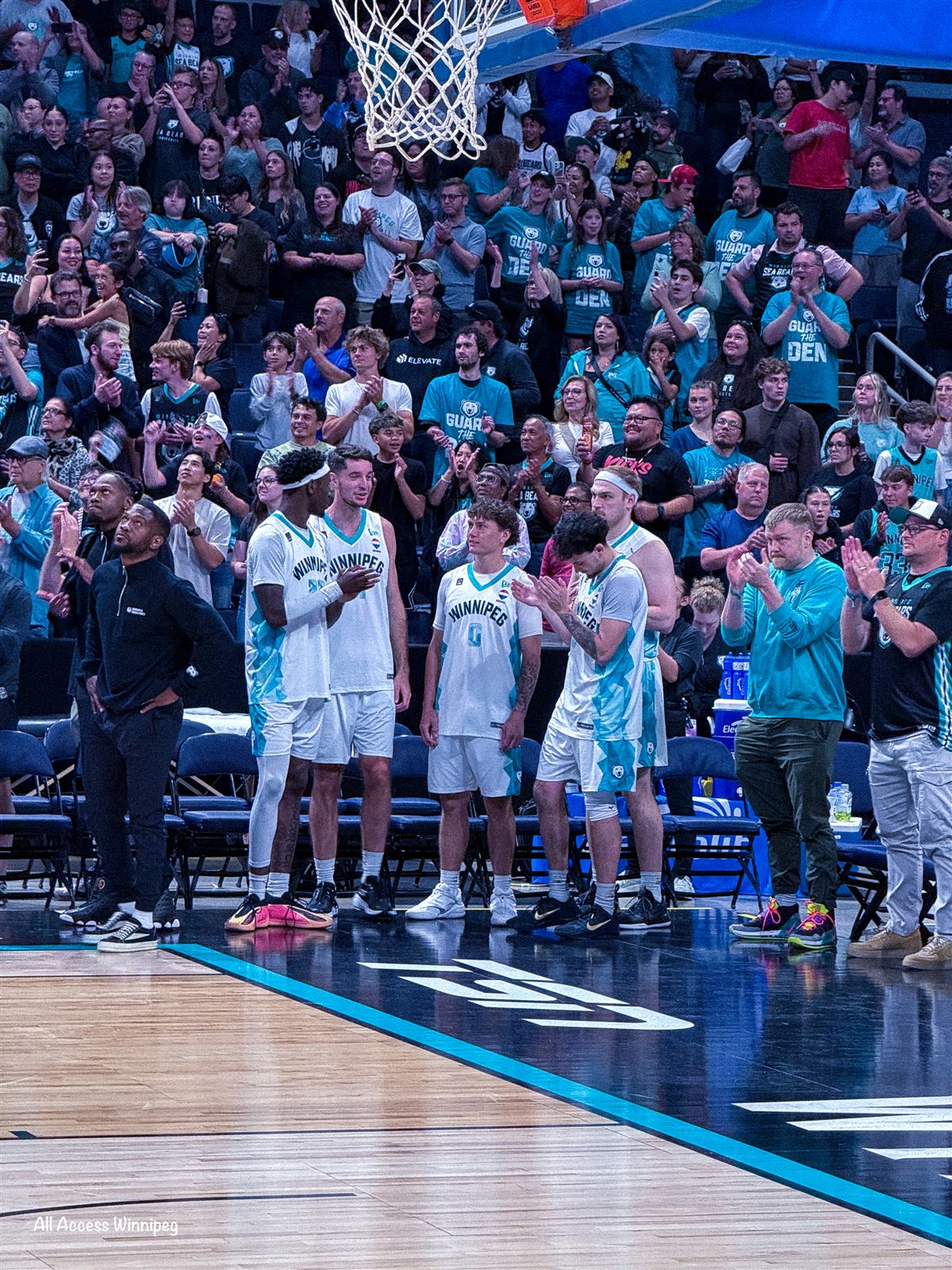 Sea Bears players lined up courtside as the crowd cheers "Guard the Den"