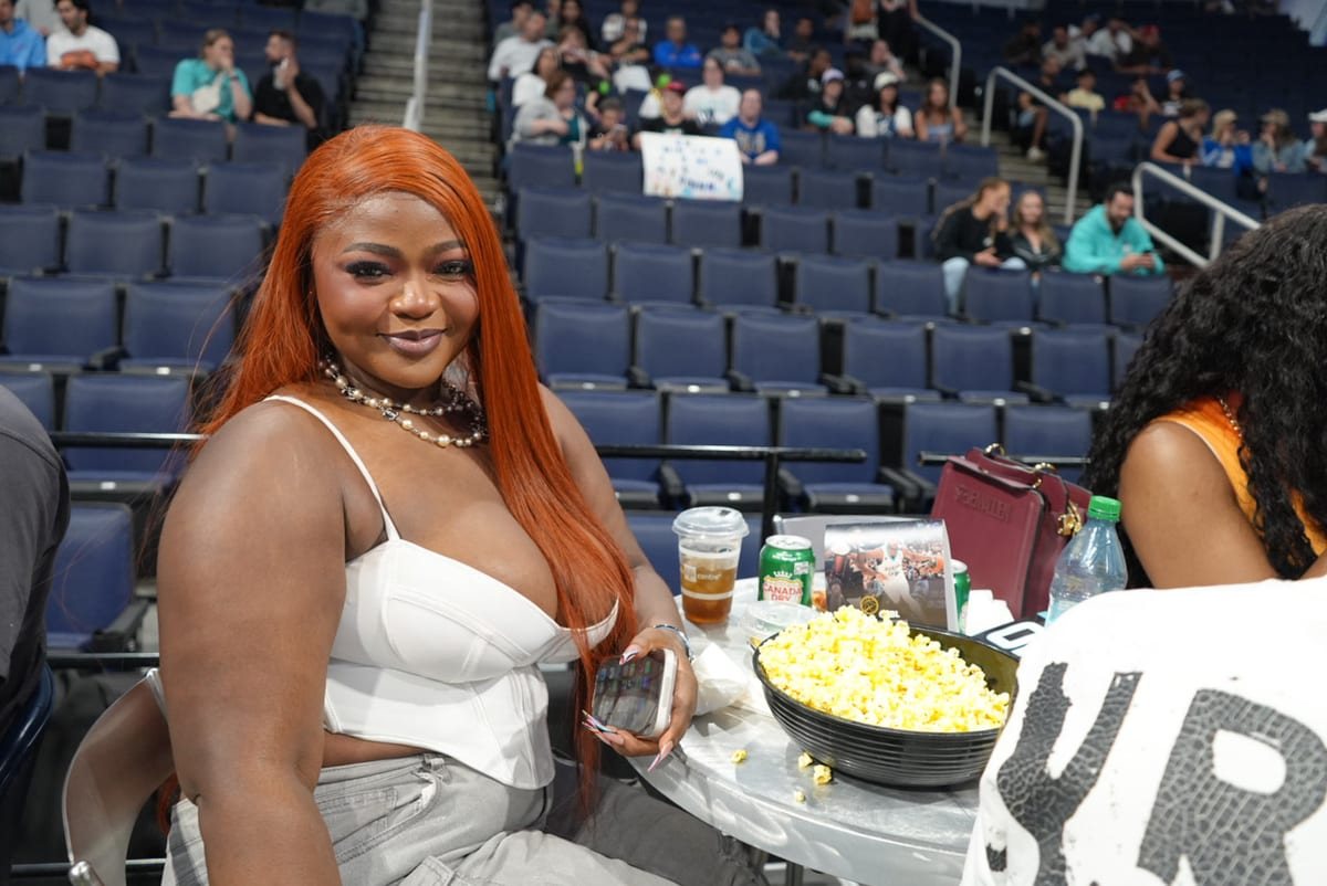 Guest smiling courtside at the table, Founding 15 launch