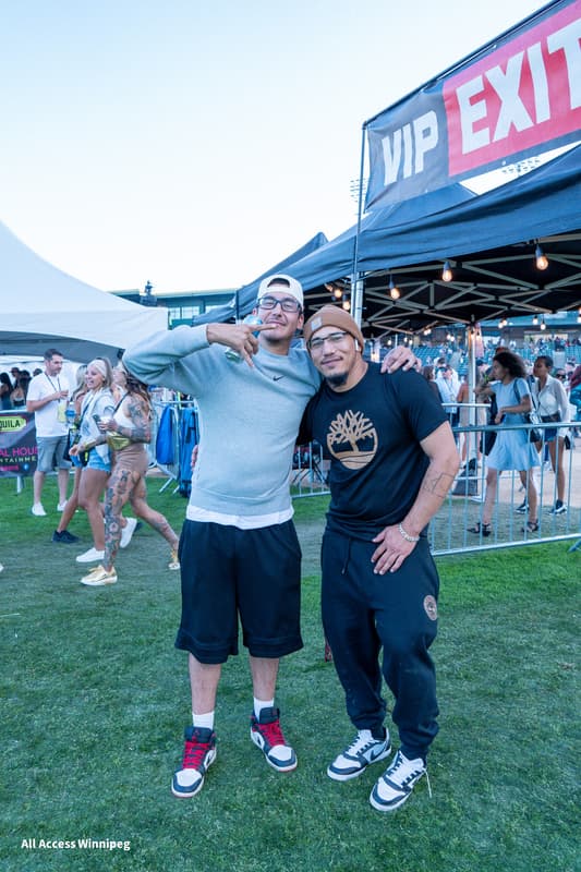 Two guests posed together near the VIP entrance signage