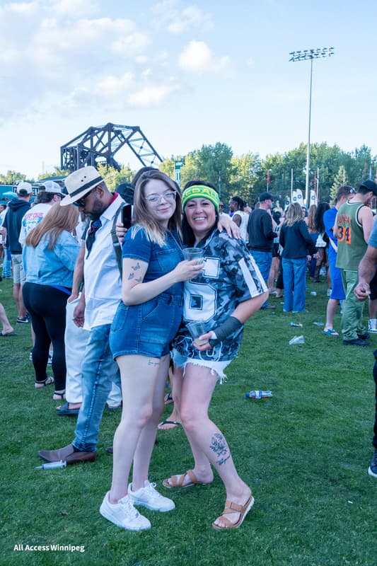 Two guests arm in arm on the festival grounds