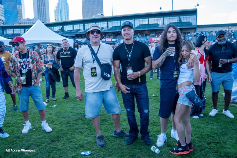 Six guests posed together with VIP lanyards on the festival grounds
