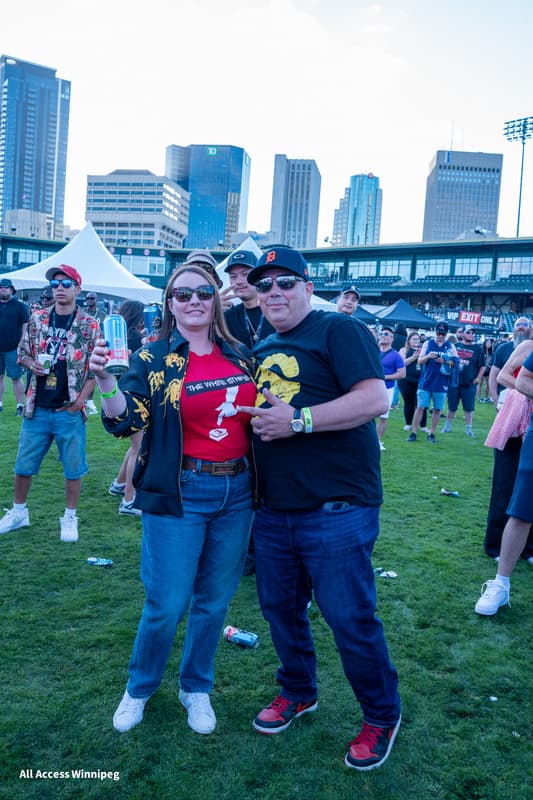 Couple posed together with the Winnipeg skyline at dusk