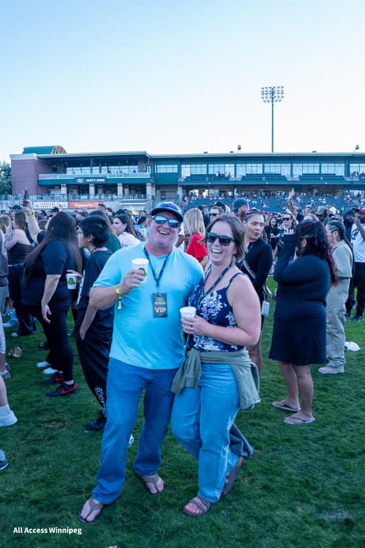 Couple posed together with the festival crowd behind them