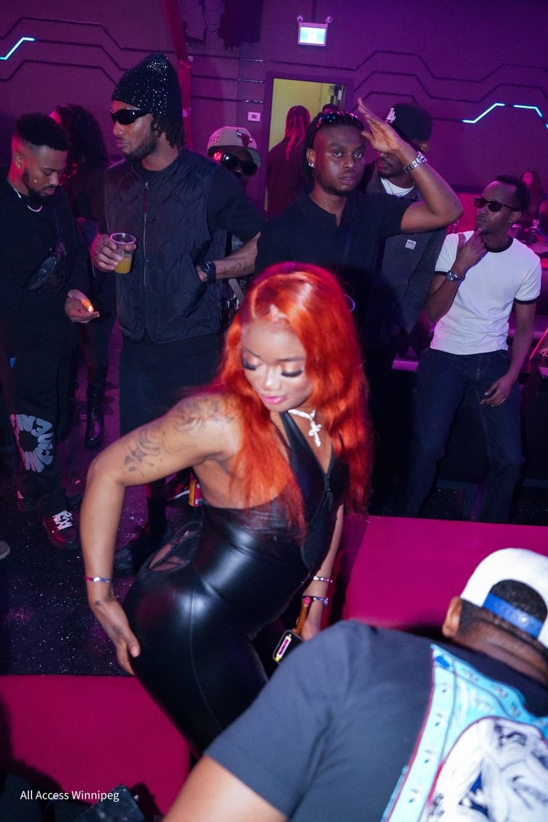 Guest with orange-red hair dancing in a black latex dress on the dance floor