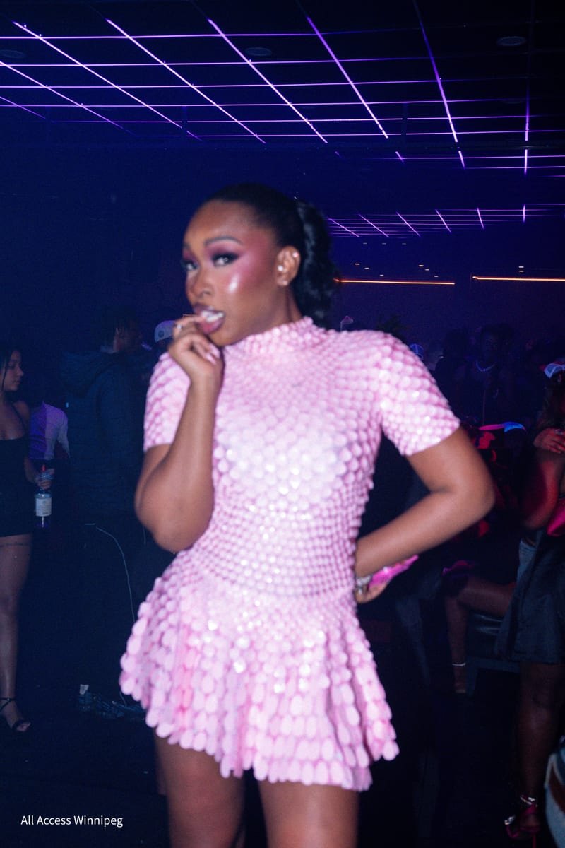 Guest in a pink sculpted dress under the club's blue and purple lasers