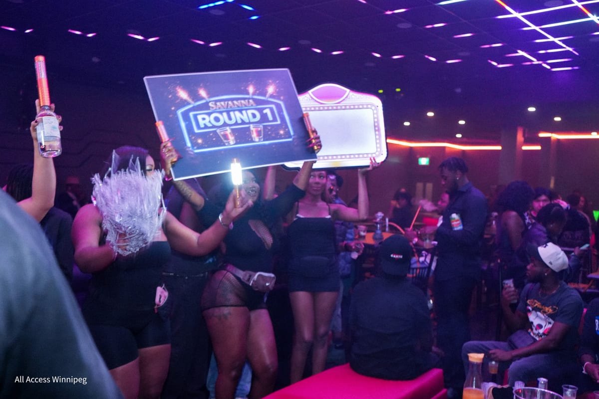 Bottle-service hosts raising the ROUND 1 sign and sparklers under the laser ceiling