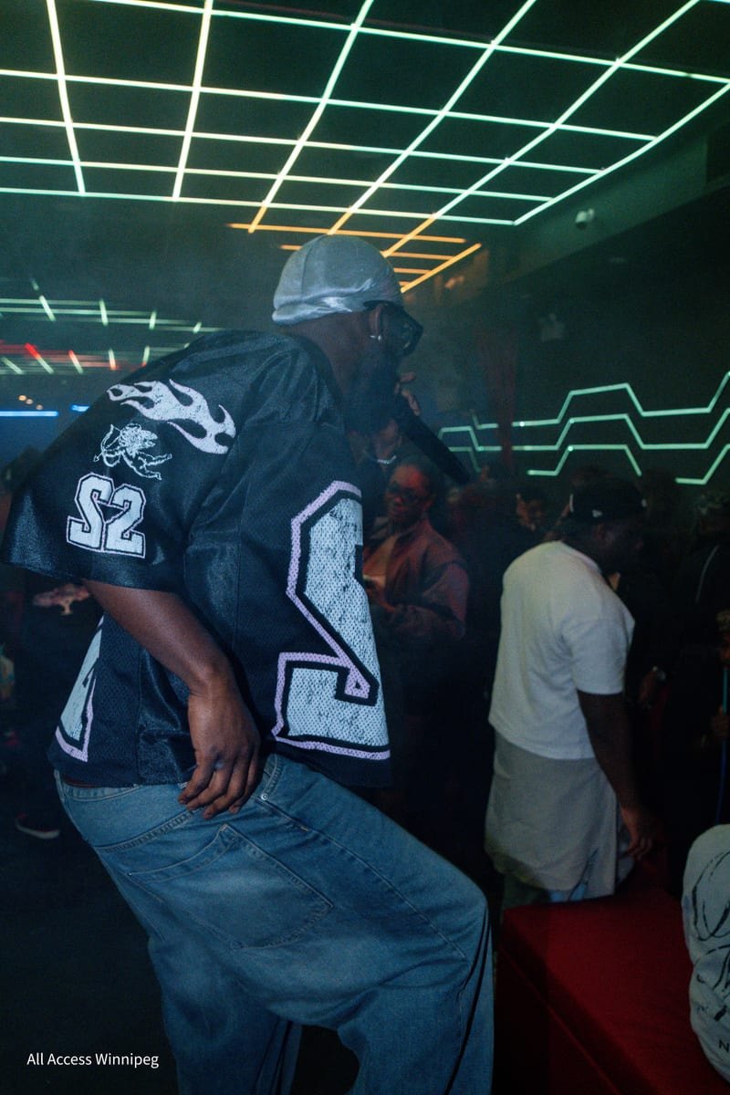 Guest dancing in a laser-lit room under green and orange ceiling lights