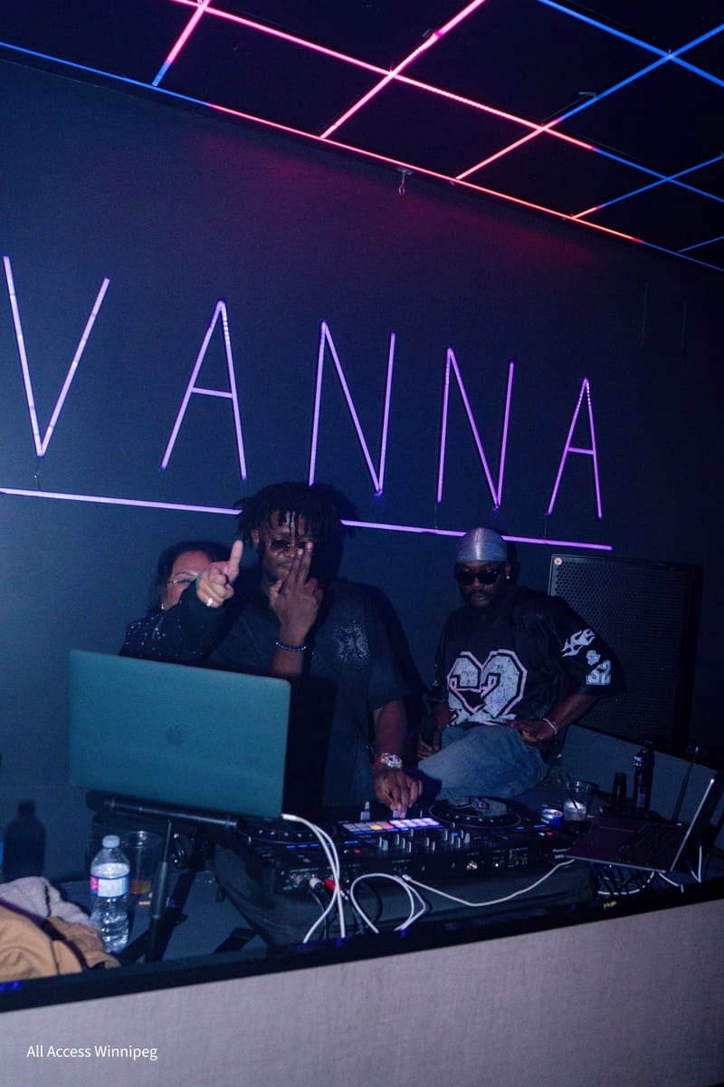 DJ booth under the neon sign with pink and blue ceiling lasers