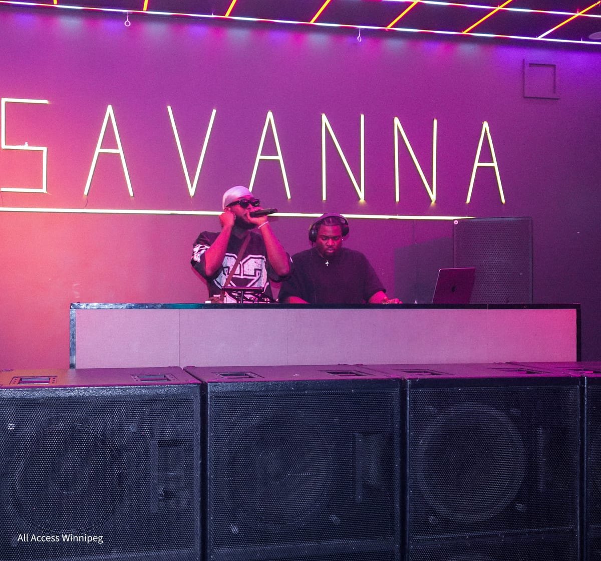 Wide view of the DJ booth beneath the SAVANNA neon sign